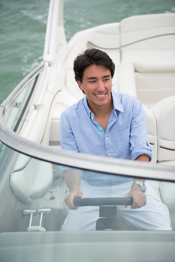 Handsome man driving a Lagoo boat and enjoying the summer